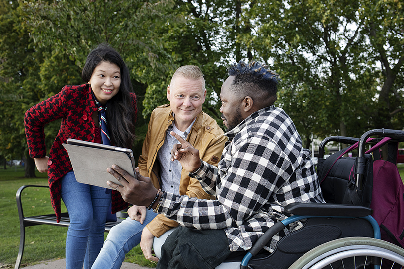 three persons with a tablet