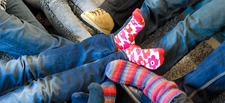 Lähikuva jaloista, joissa on erivärisiä sukkia.