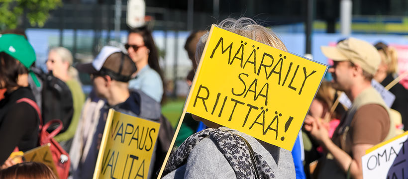 Ihmisjoukossa näkyy Määräily saa riittää! -kyltti.